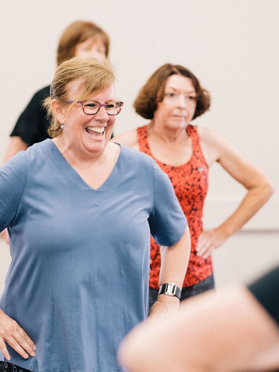 A group of adults smiling during a movement class.