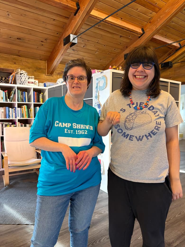Two CreatAbility participants standing side by side in the studio, both grinning.